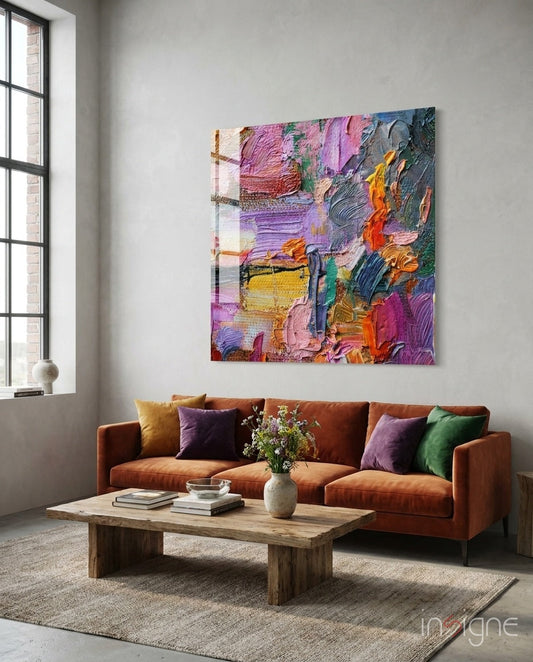 Vibrant multicolored impasto glass art panel hanging above an orange sofa in a contemporary living room setting.