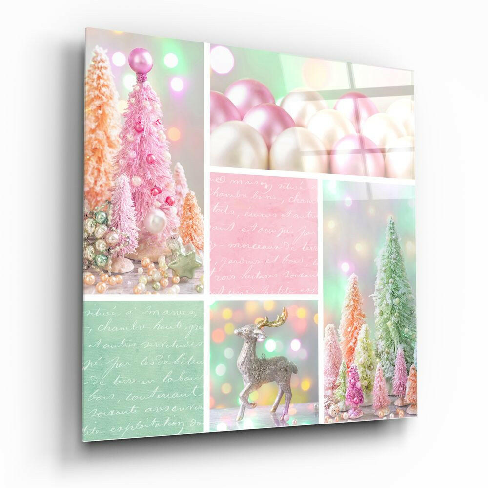 Angled view of a glass wall art panel displaying a collage of pink and green Christmas trees, baubles, a silver reindeer figurine, and handwritten text on pastel backgrounds.