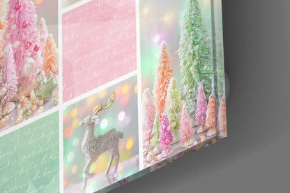 Angled view of glass wall art displaying colorful frosted trees, silver reindeer, and handwritten text on pink and green panels with bokeh lighting.