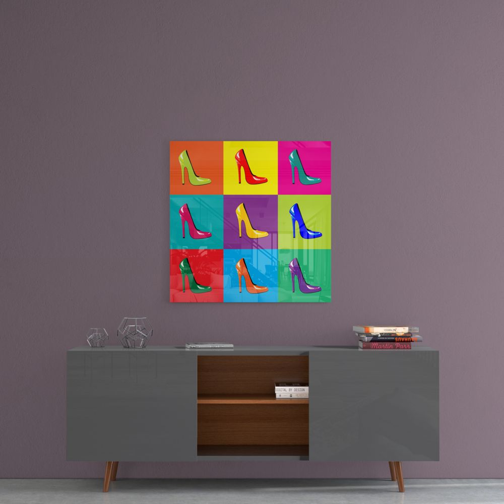 Pop art-style glass wall art displaying nine colorful high-heeled shoes in a 3x3 grid mounted above a gray sideboard.