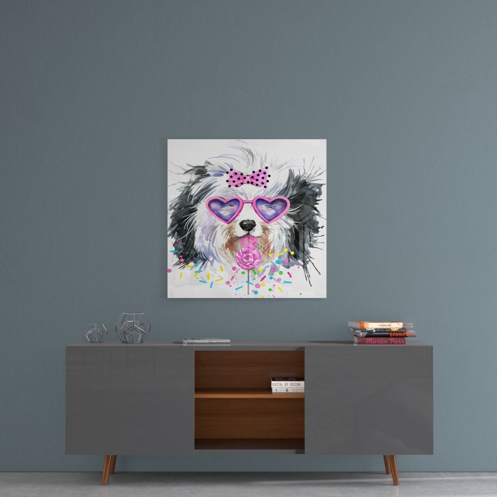 Framed glass wall art of a black and white dog wearing purple heart-shaped sunglasses and pink bow, displayed above a mid-century modern credenza against a blue-gray wall.
