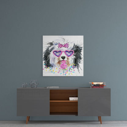 Framed glass wall art of a black and white dog wearing purple heart-shaped sunglasses and pink bow, displayed above a mid-century modern credenza against a blue-gray wall.