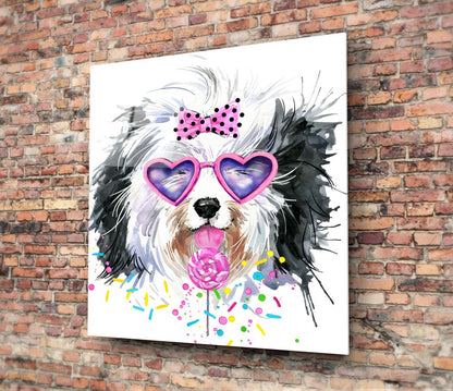 Colorful glass wall art of a fluffy dog wearing pink heart sunglasses and holding a pink flower, mounted on red brick wall.