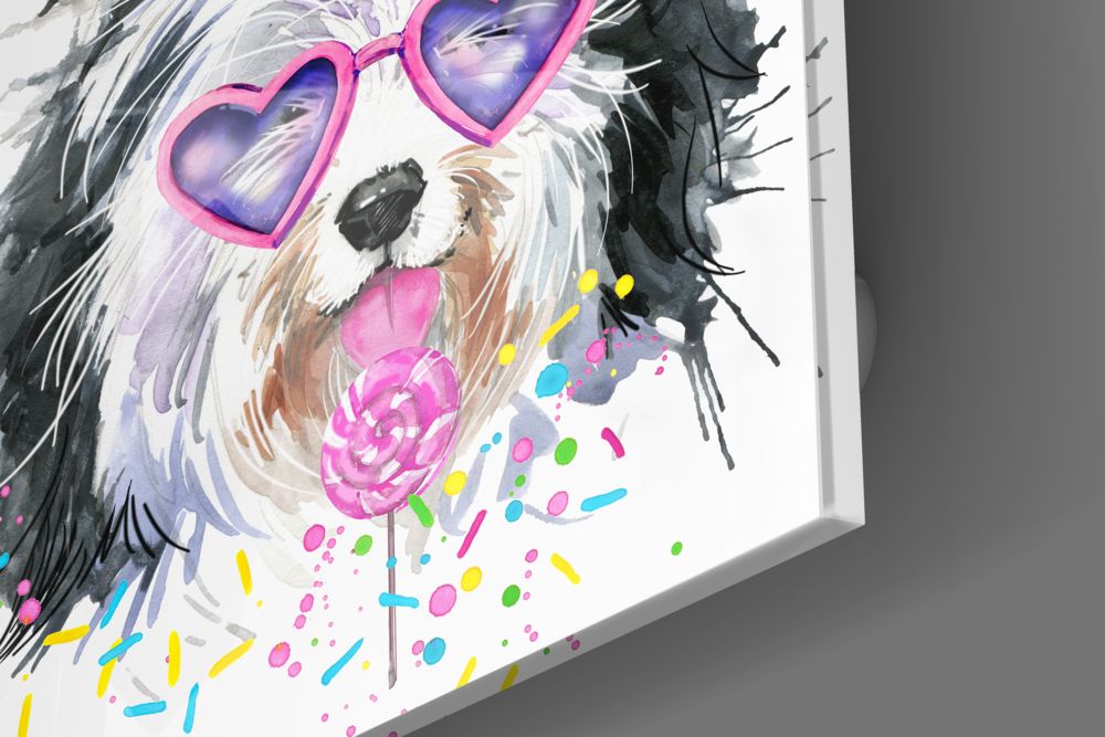 Angled view of glass wall art featuring a fluffy dog wearing pink heart-shaped sunglasses and holding a lollipop surrounded by colorful paint splatters.