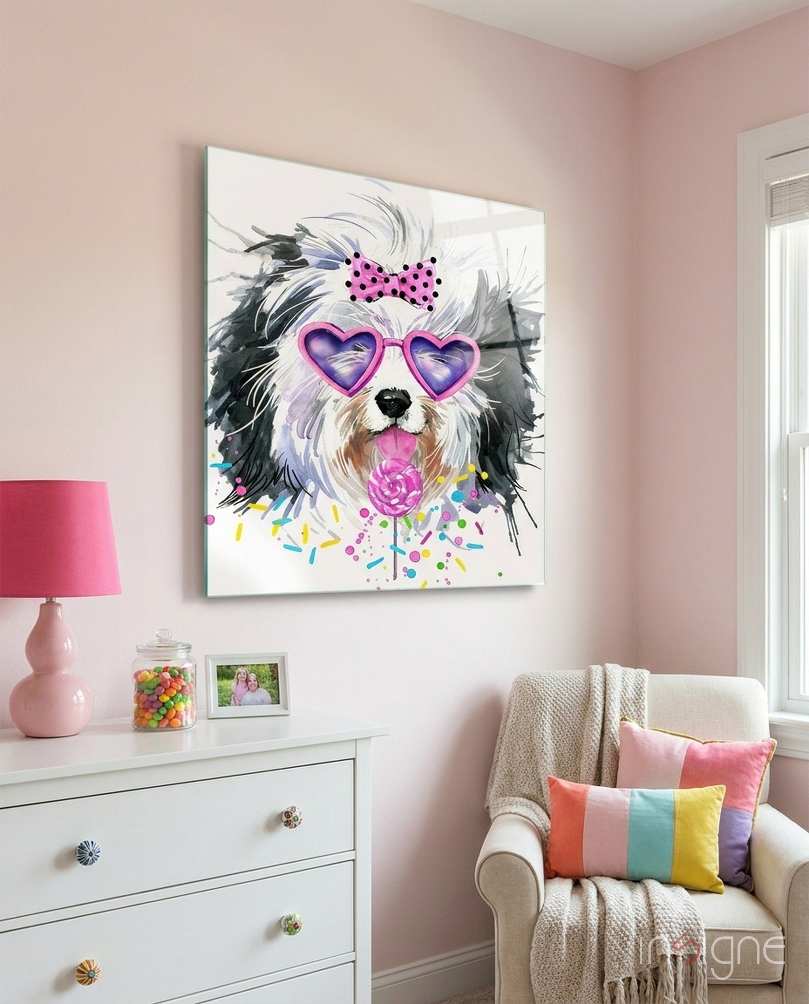 Whimsical dog wearing heart-shaped sunglasses and polka dot bow displayed on pink bedroom wall above white dresser.