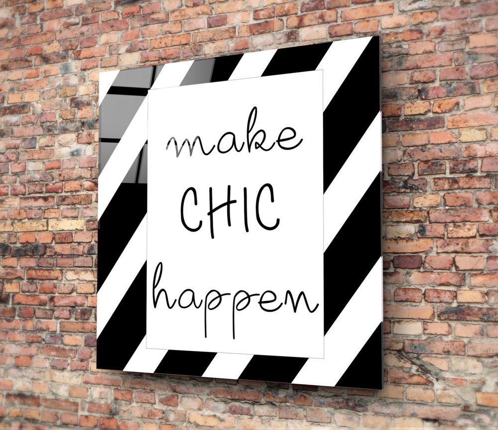Black and white striped glass wall art with "make chic happen" handwritten text, mounted on red brick wall.