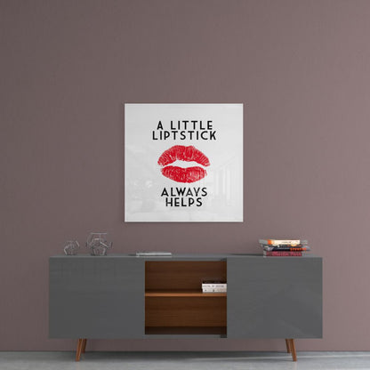 Square glass wall art with red lipstick kiss mark and black text reading "A LITTLE LIPSTICK ALWAYS HELPS" displayed above modern sideboard.