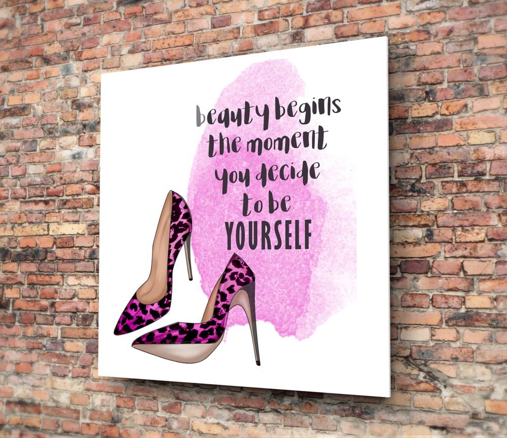 Glass wall art with pink watercolor background, magenta leopard print heels, and black motivational text mounted on brick wall.
