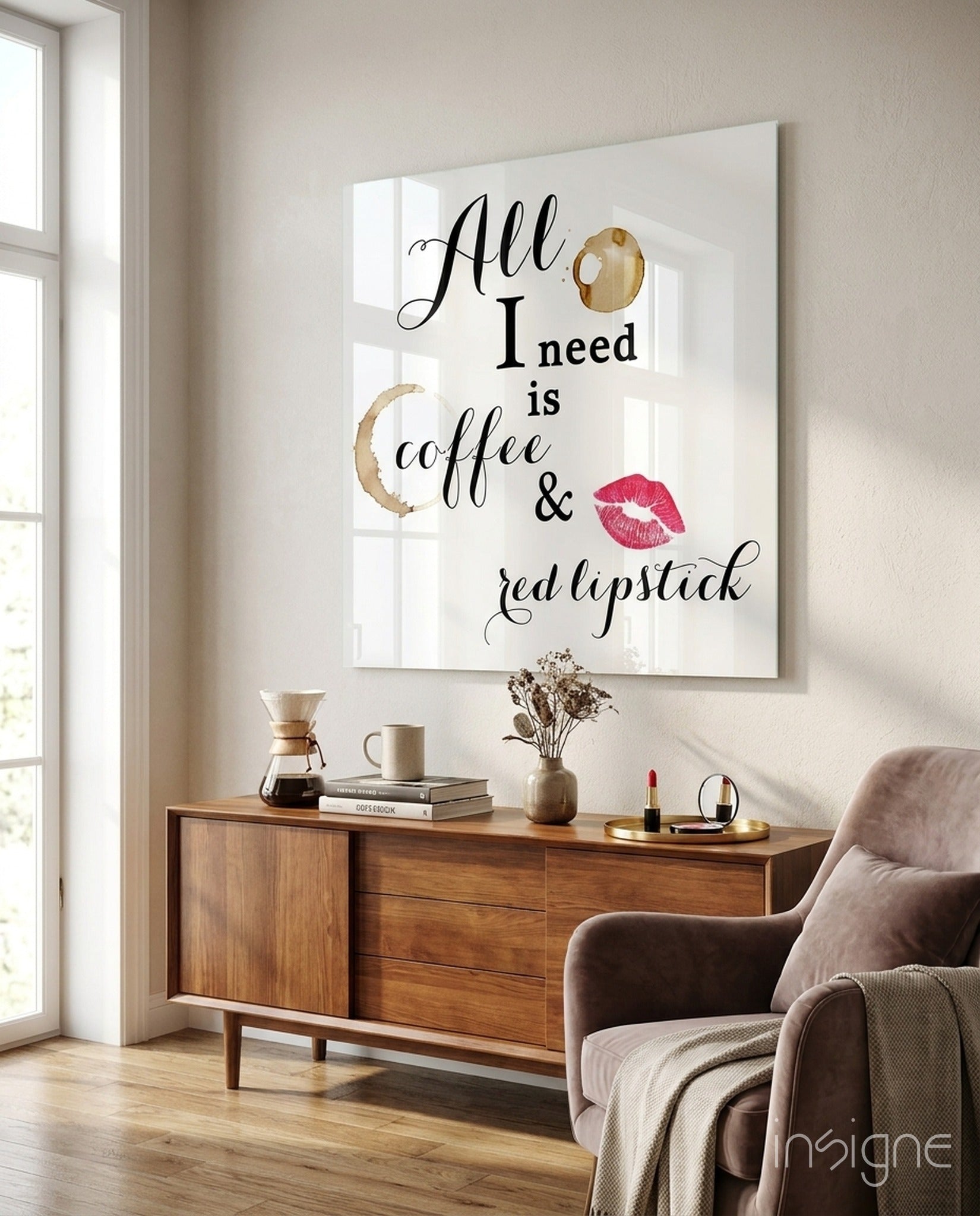 White glass wall art displaying "All I need is coffee & red lipstick" text with coffee stain and lip print graphics, mounted above wooden dresser in modern bedroom.