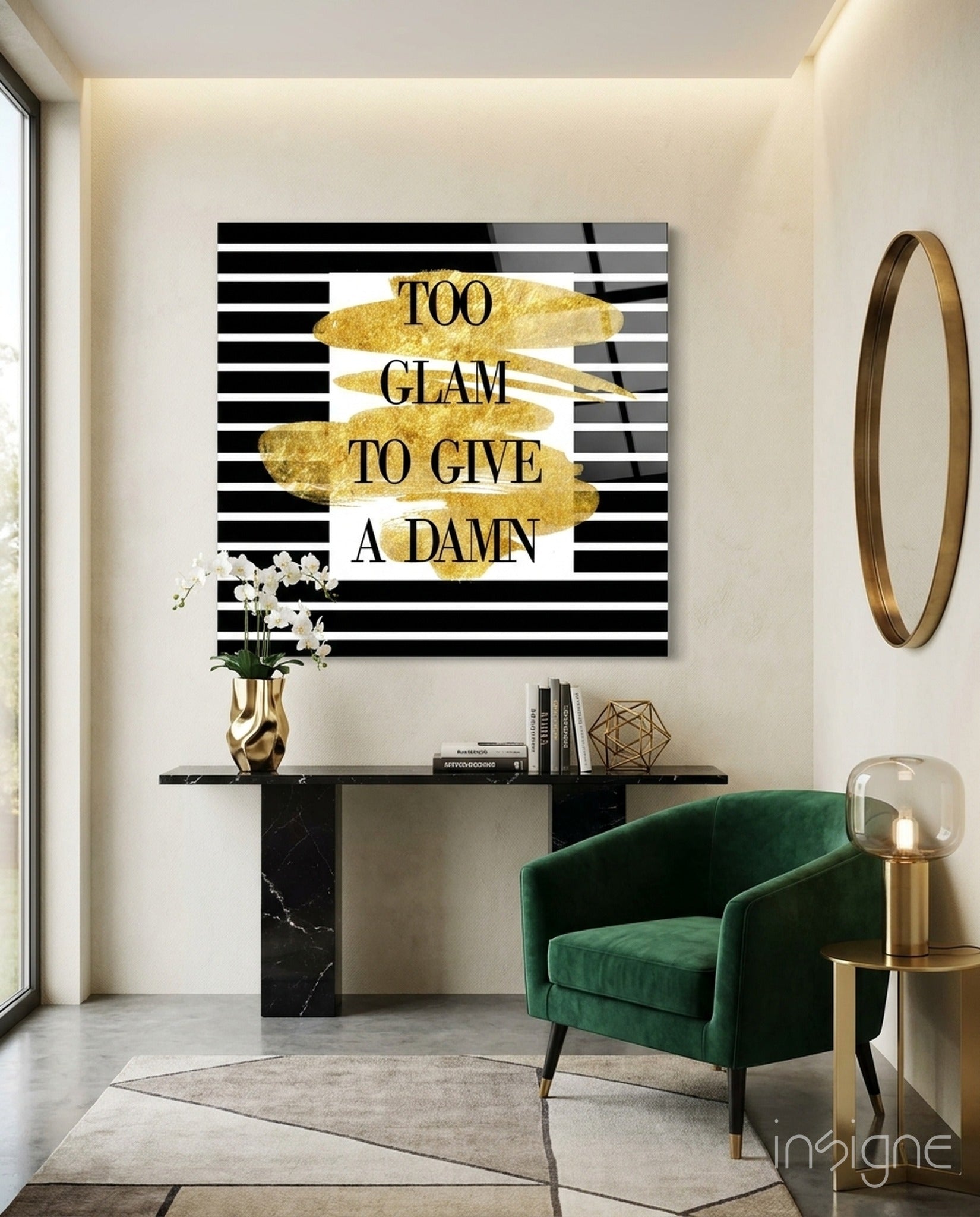 Black and white striped glass wall art with gold leaf accents displaying "TOO GLAM TO GIVE A DAMN" text in modern living room setting.