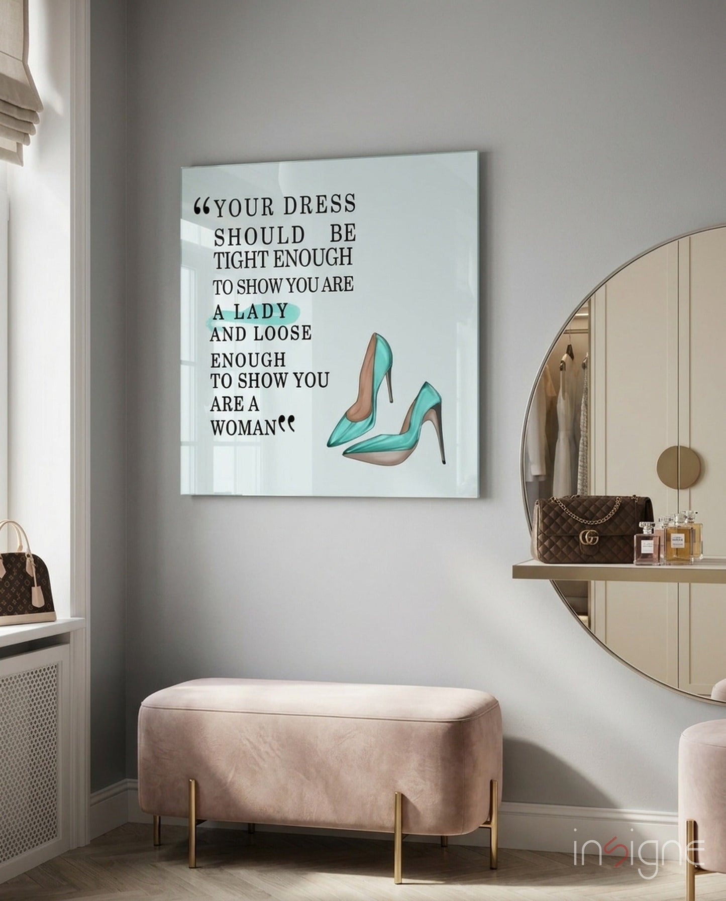 Glass wall art with black text quote and teal high-heeled shoes displayed above pink velvet bench in modern bedroom.