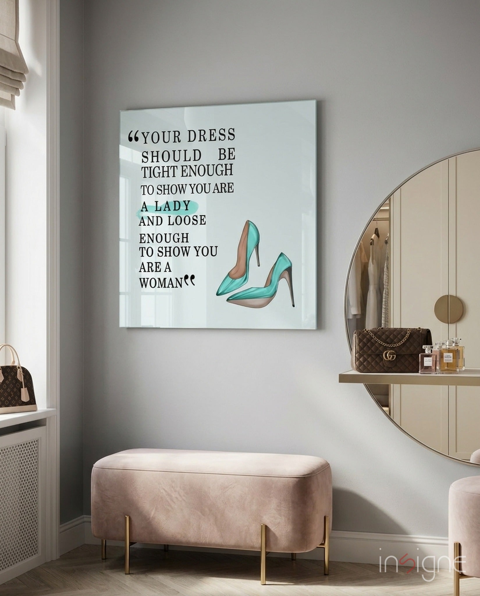 Glass wall art with black text quote and teal high-heeled shoes displayed above pink velvet bench in modern bedroom.