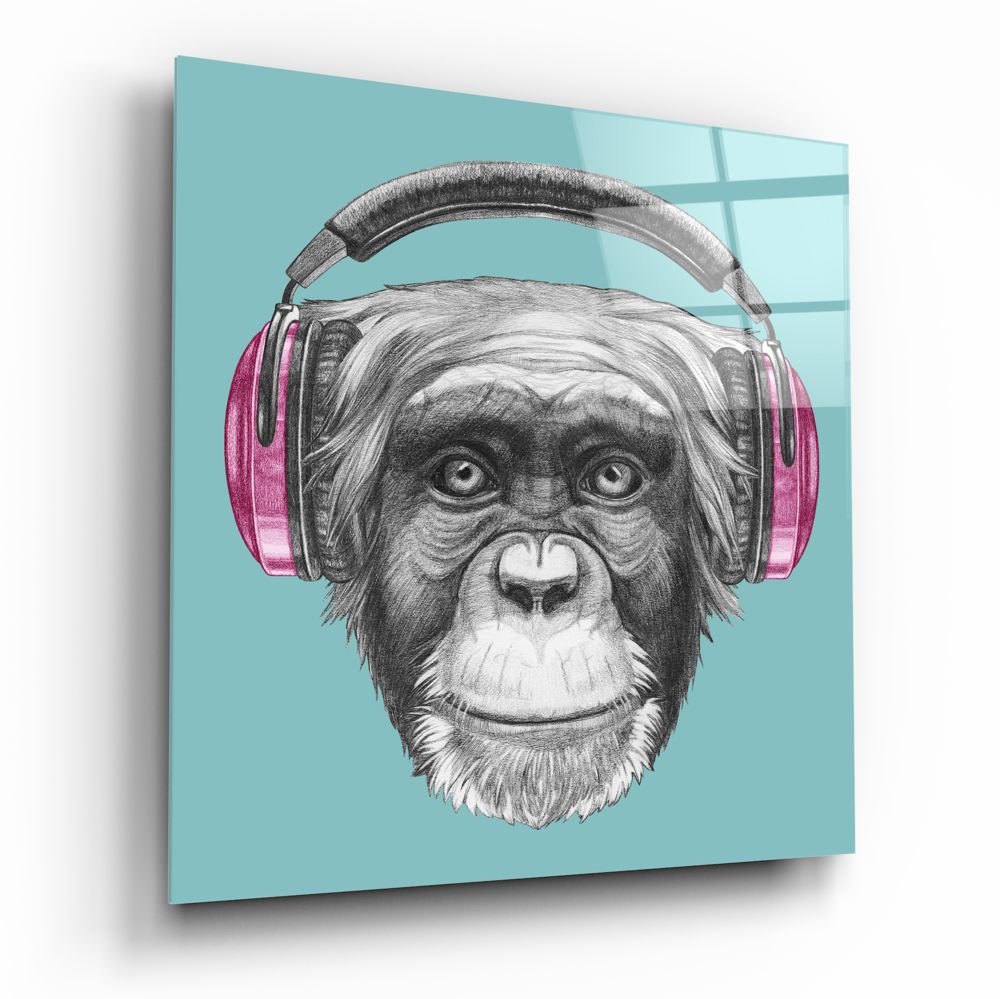 Angled view of turquoise glass wall art featuring a sketched chimpanzee wearing pink headphones against a light blue background.