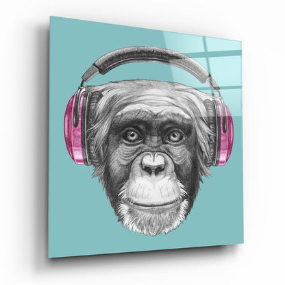 Angled view of turquoise glass wall art featuring a sketched chimpanzee wearing pink headphones against a light blue background.