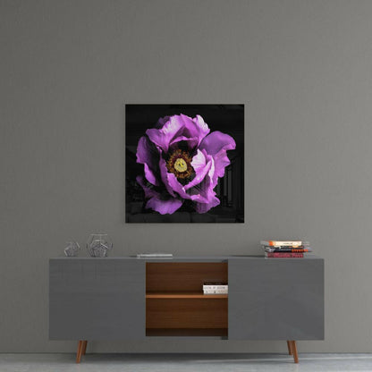 Square glass wall art featuring a vibrant magenta peony flower with yellow center displayed above a modern gray and wood console table.