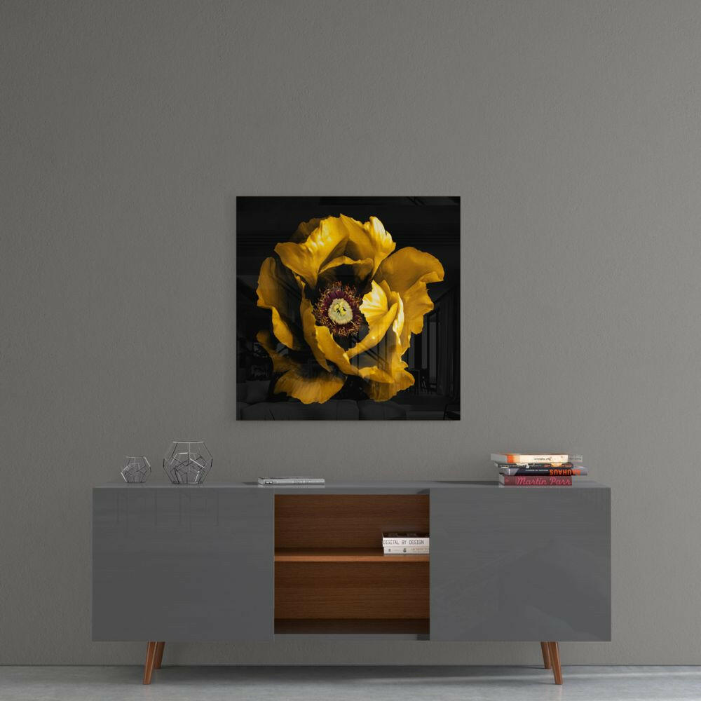 Yellow peony flower with dark center displayed as glass wall art above gray mid-century modern console table.