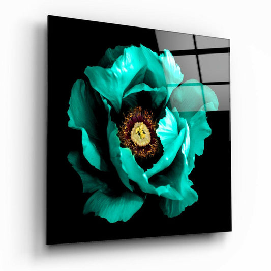 Angled product view of a glass wall art panel displaying a turquoise peony with dark burgundy center and yellow stamens against black background.