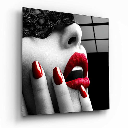 Close-up of a woman's face with red lipstick and red nail polish, wearing a black lace mask, against a black and white geometric background.