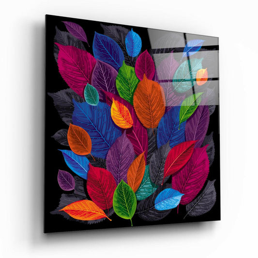 Angled perspective view of a black glass wall art panel displaying vibrant multicolored leaves in jewel tones including magenta, blue, orange, green, and purple against a dark background.