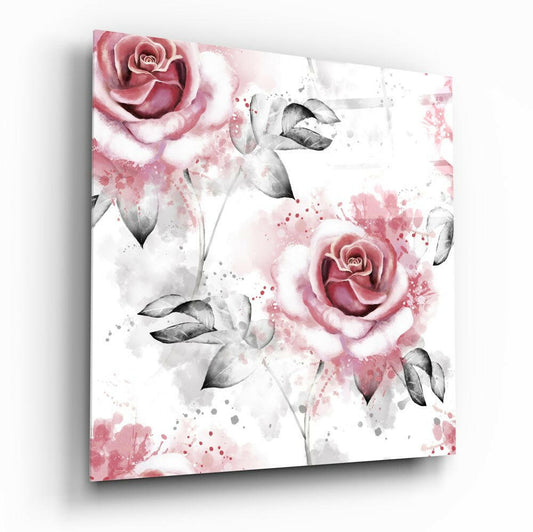Angled view of glass wall art displaying watercolor pink roses with gray leaves and splattered pink and gray accents on white background.