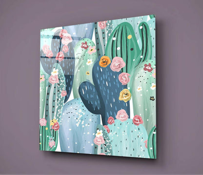 Square glass wall art panel displaying illustrated cacti with pink and yellow flowers against a soft blue-green background, mounted on a purple wall.