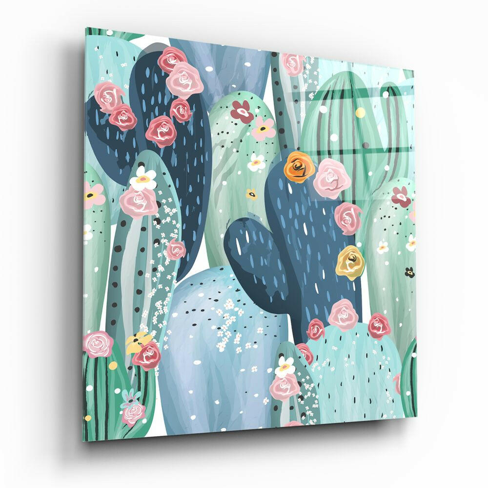 Square glass wall art panel angled to show depth, featuring illustrated cacti with pink and yellow flowers on mint green background.