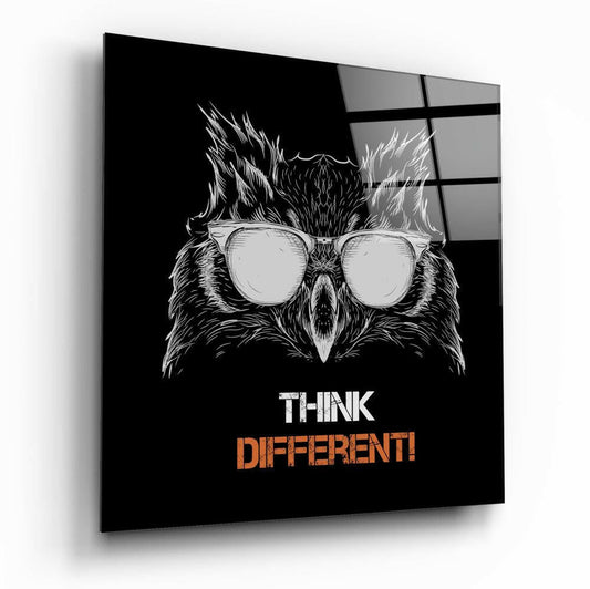 Black glass wall art panel displaying a sketched owl wearing round sunglasses with "THINK DIFFERENT!" text in white and orange, viewed at an angle.