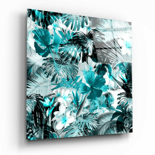 Angled perspective of square glass wall art featuring turquoise, white, and black tropical flowers and palm leaves against white background.