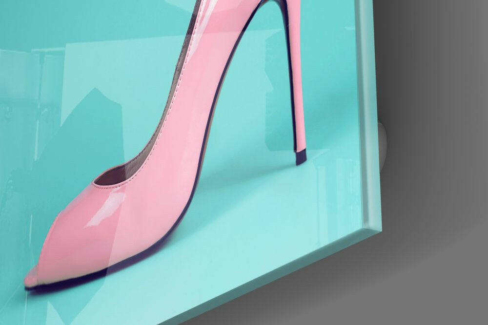 Pink heeled shoe displayed against turquoise glass wall, side profile view showing glossy finish and pointed toe.