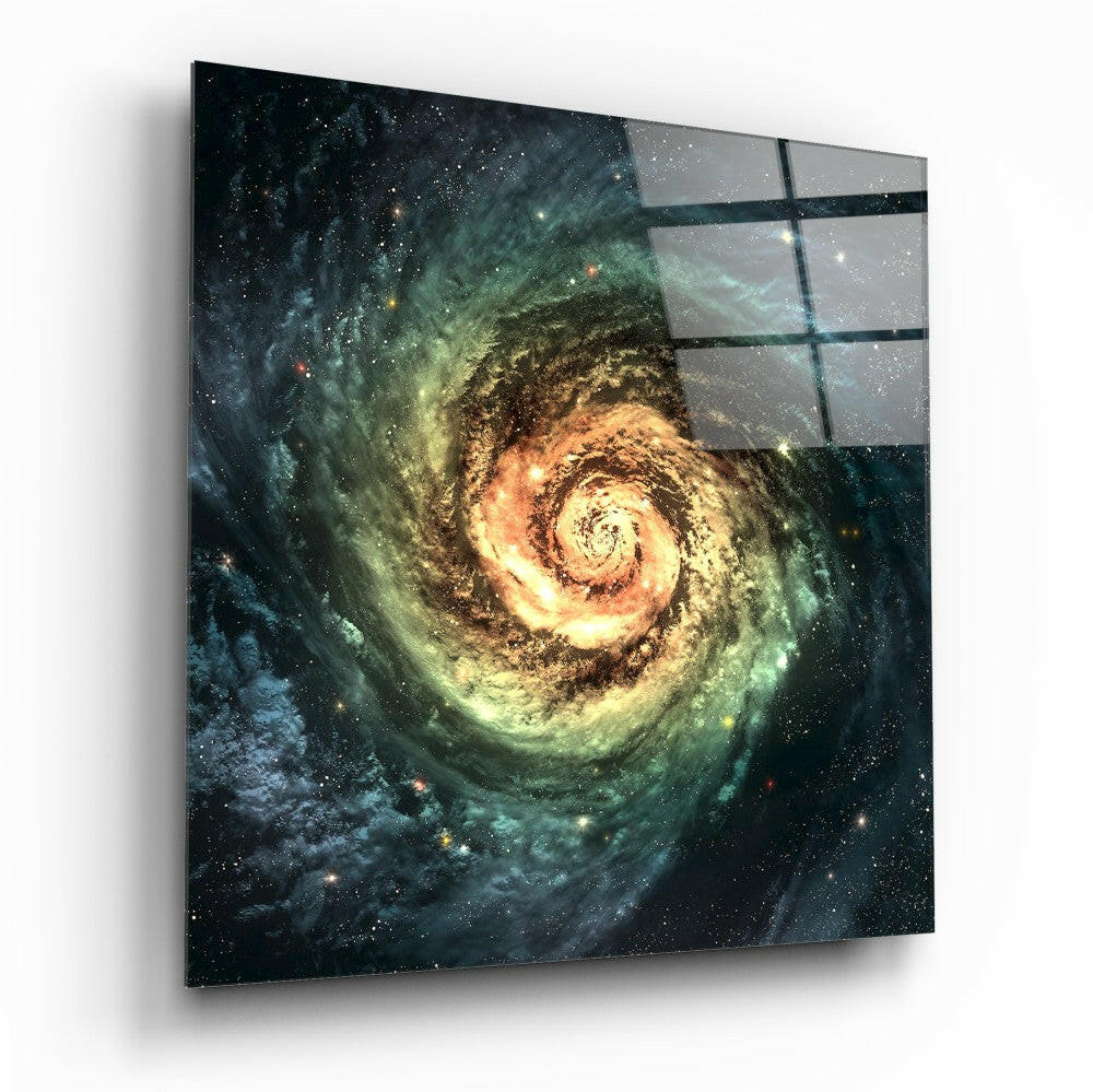 Angled view of glass wall art displaying a spiral galaxy with golden core and green outer rings against starry black background, mounted on white wall.