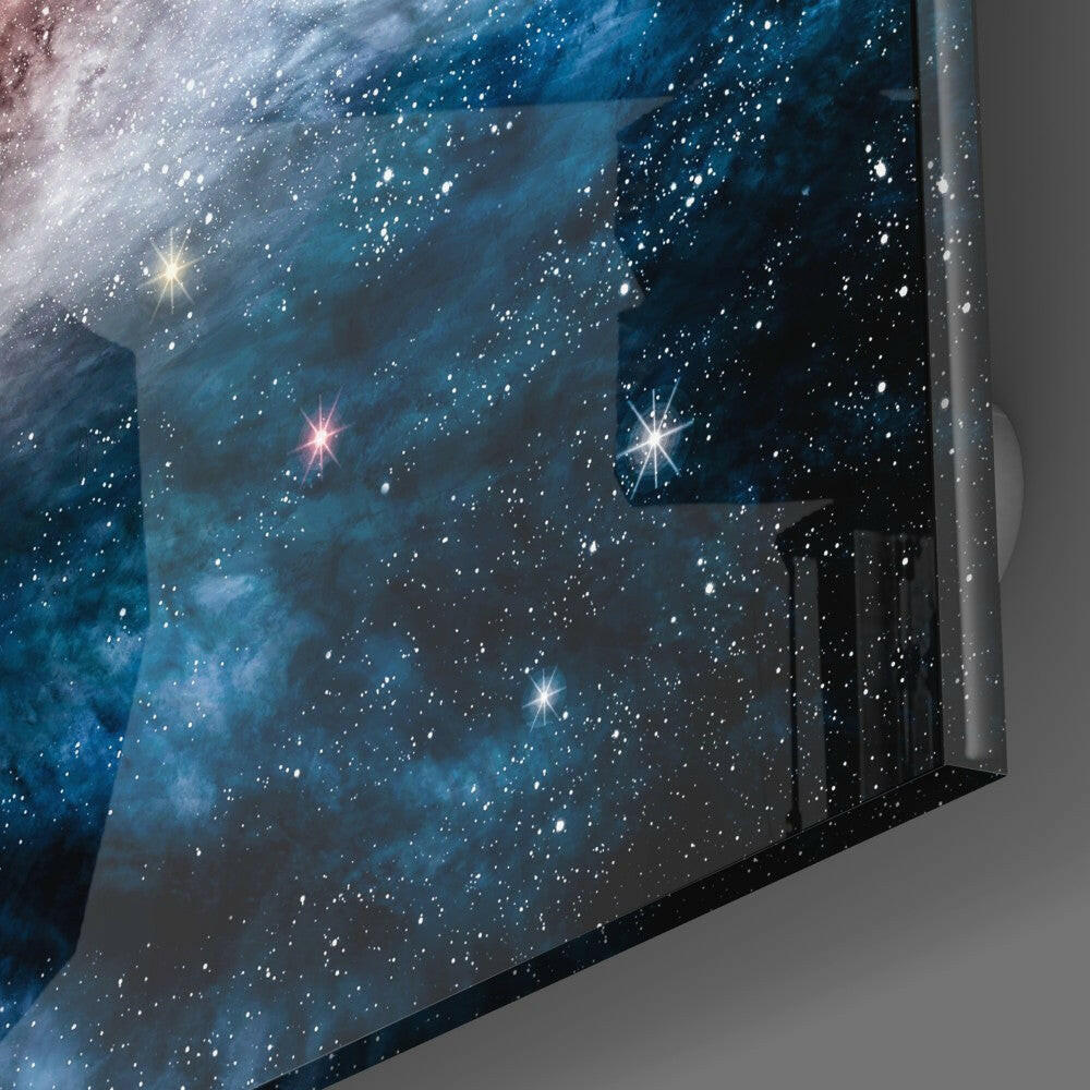Blue Infinity Glass Wall Art displayed at an angle showing a starfield with bright stars and nebula clouds against gray wall background.