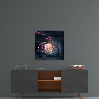 Black hole glass wall art with pink and white spiral galaxy displayed on gray wall above mid-century modern console table.