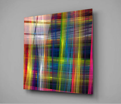 Colorful Touches Glass Wall Art displayed at an angle against a gray wall, showing vibrant vertical and horizontal streaks of red, pink, yellow, blue, and green.