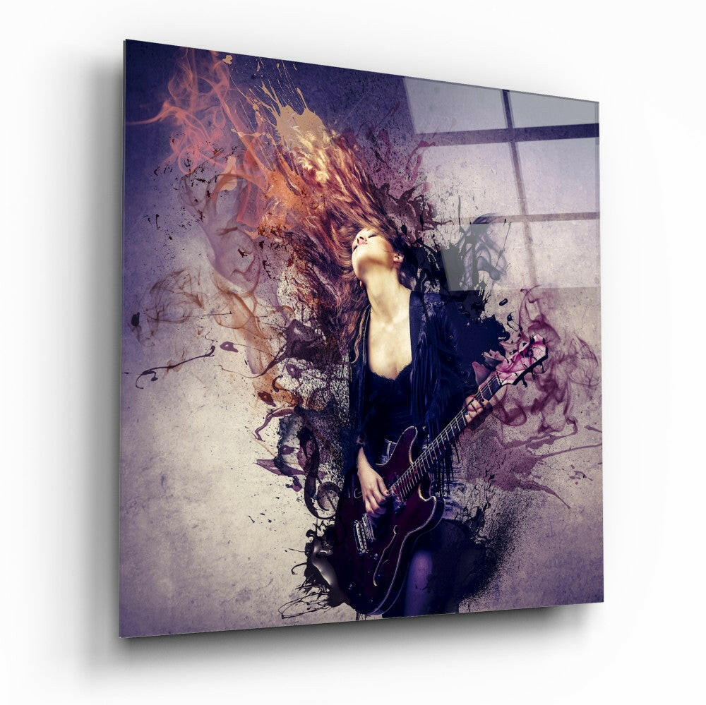 Glass wall art displaying a woman with long hair holding an electric guitar, surrounded by purple and orange abstract splatter effects and window shadows.