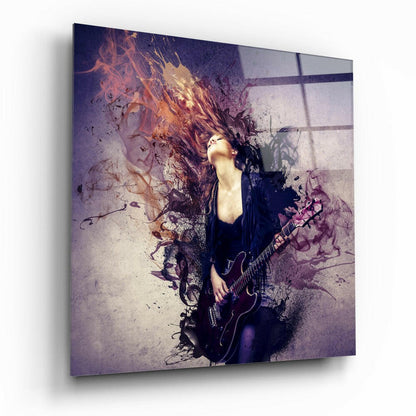 Glass wall art displaying a woman with long hair holding an electric guitar, surrounded by purple and orange abstract splatter effects and window shadows.