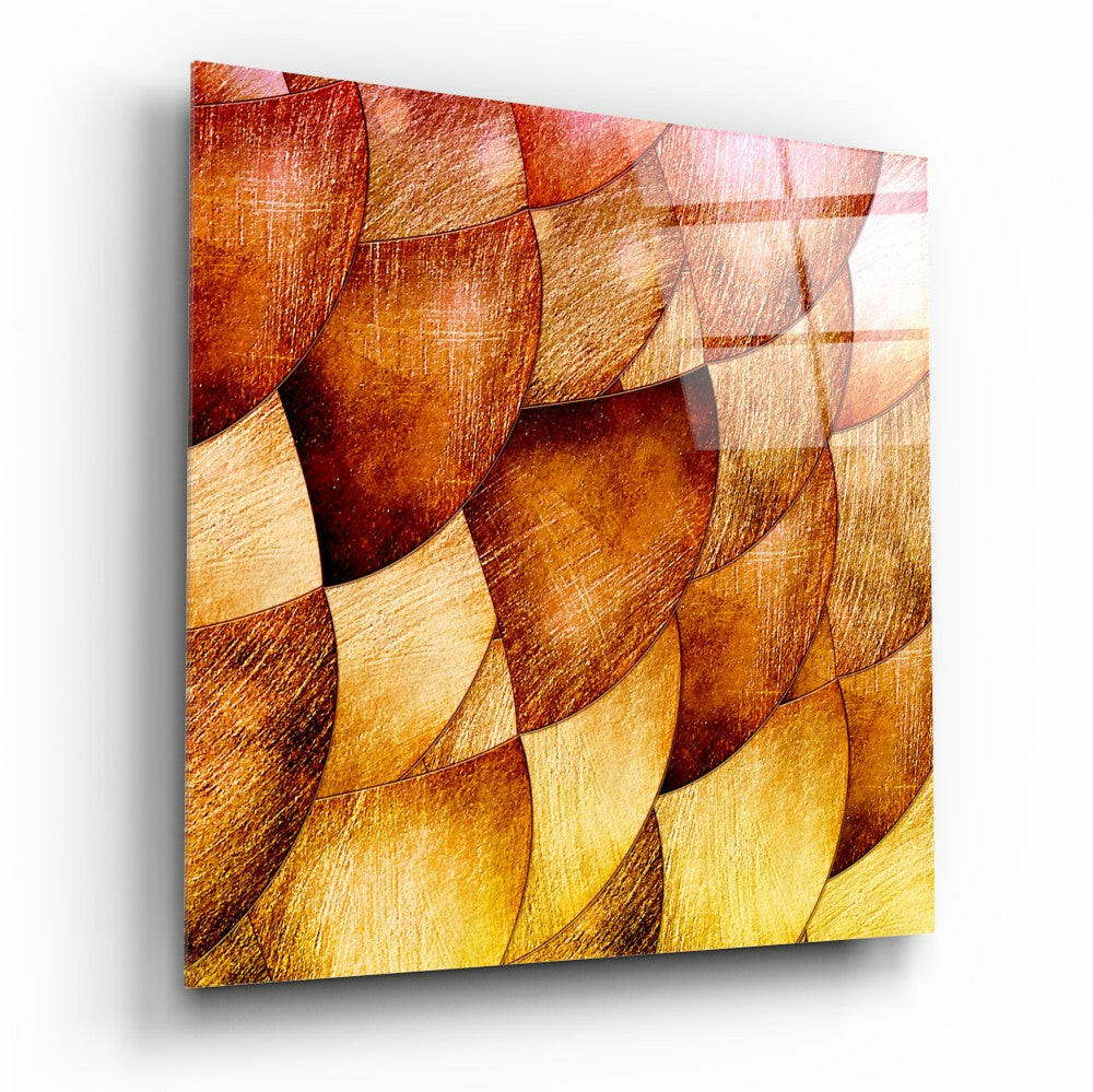 Glass wall art panel with overlapping curved shapes in warm gold, amber, and deep red tones with textured surface, angled three-quarter view.