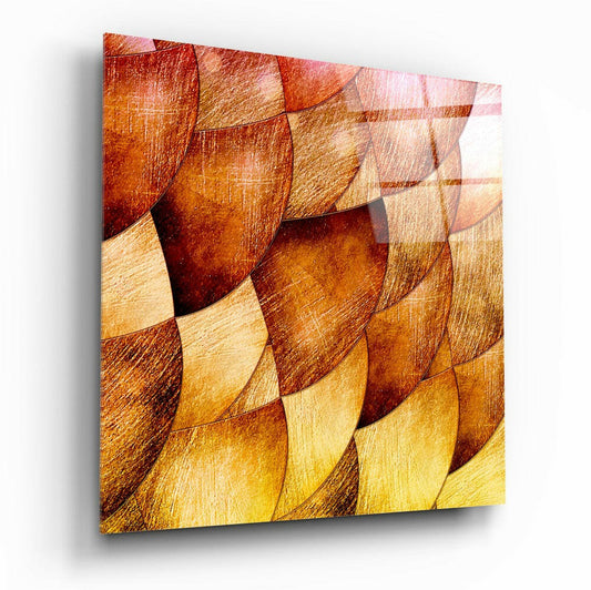 Glass wall art panel with overlapping curved shapes in warm gold, amber, and deep red tones with textured surface, angled three-quarter view.