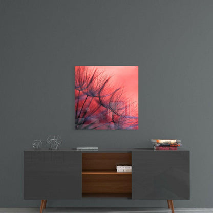 Red dandelion glass art hanging above a mid-century modern console table with decorative objects and books.