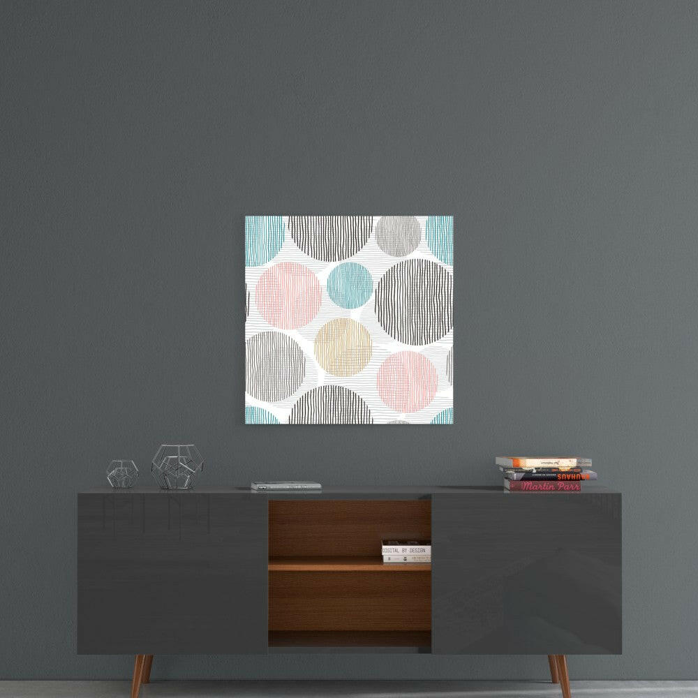 Soft Spots Glass Wall Art displayed above a mid-century modern credenza, featuring pastel circles in pink, blue, tan, and black striped patterns on white background.
