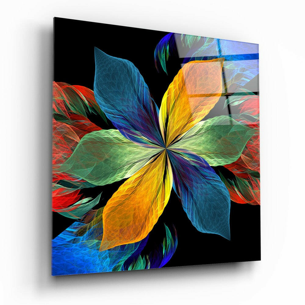 Angled perspective view of a glass wall art panel featuring a vibrant flower with radiating petals in blue, yellow, red, and green against a black background.
