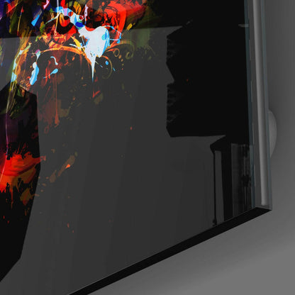 Angled side view of colorful skull glass wall art with red, blue, and yellow neon-style designs displayed against dark gray wall.