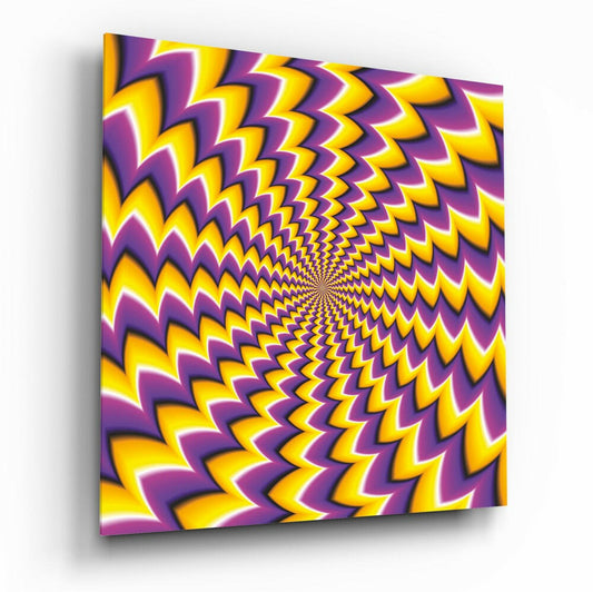 A square glass panel displaying a radiating yellow and purple chevron pattern that spirals toward the center, photographed at an angle showing the panel's depth and shadow.