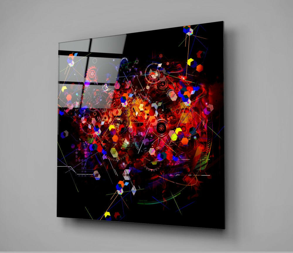 Angled perspective of large glass wall art panel displaying vibrant red, blue, yellow, and purple illuminated geometric shapes and mechanical elements against black background.