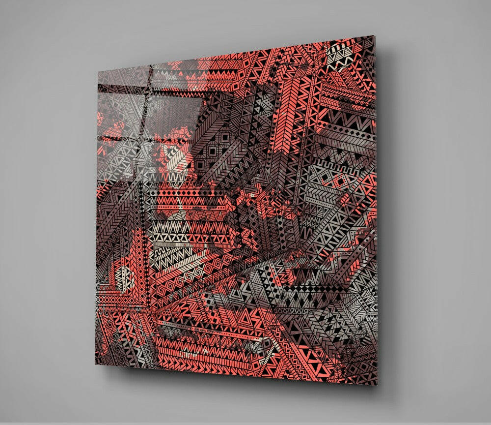 Angled perspective view of Columns Glass Wall Art displaying vibrant coral and black geometric tribal patterns on translucent glass panel.