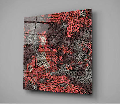 Angled perspective view of Columns Glass Wall Art displaying vibrant coral and black geometric tribal patterns on translucent glass panel.