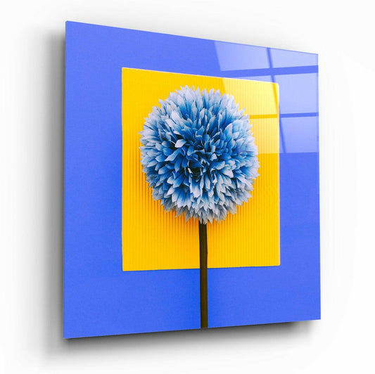 Blue and white spherical flower on yellow square against bright blue glass panel, displayed at an angle.