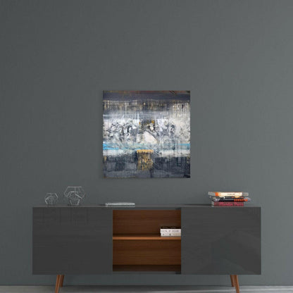 Abstract glass wall art with layered white, gray, blue, and golden tones hung above a mid-century modern credenza.
