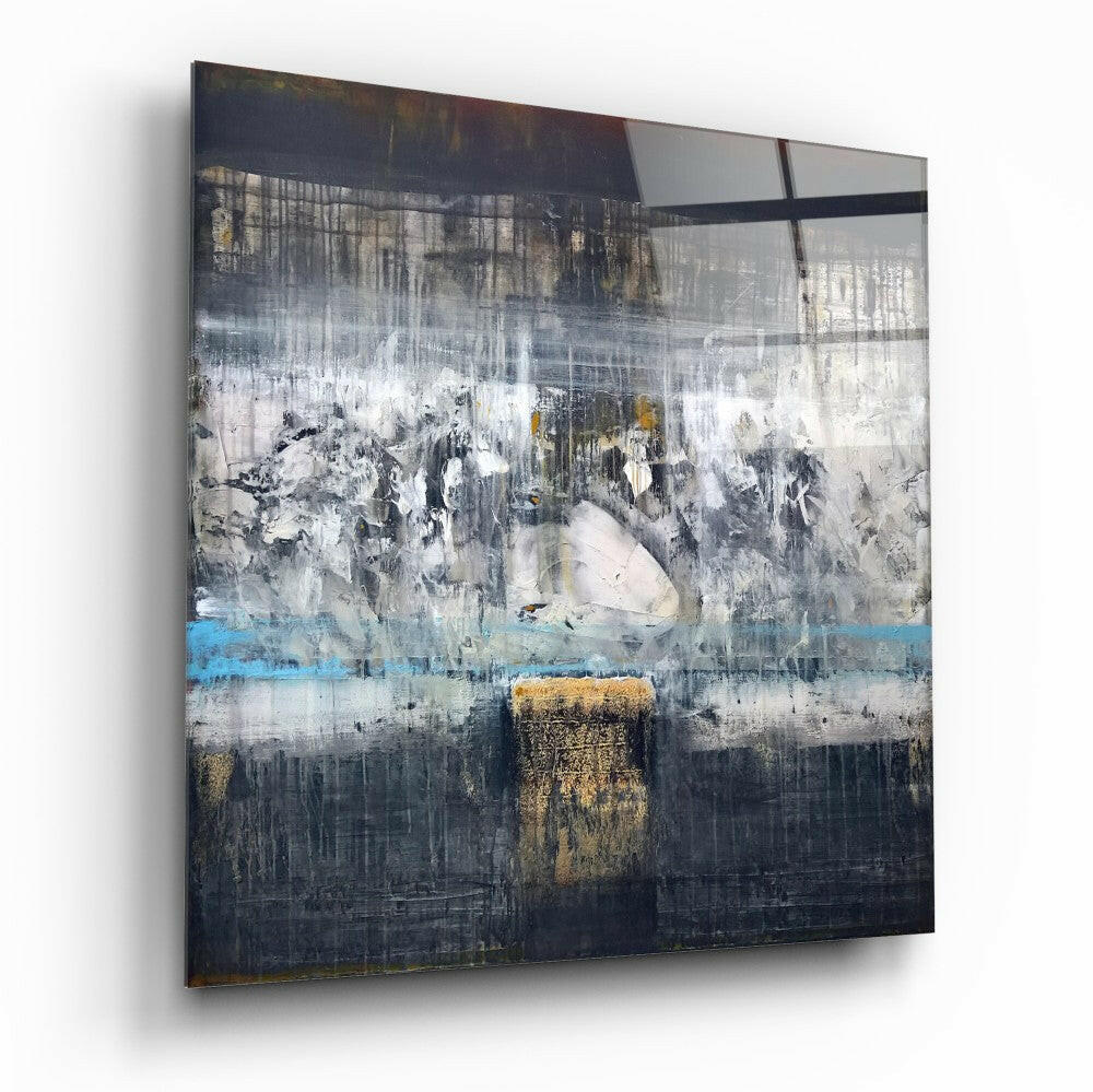 Abstract glass wall art with layered grey, white, and gold brushstrokes divided by horizontal blue and black bands, displayed at an angle against white background.