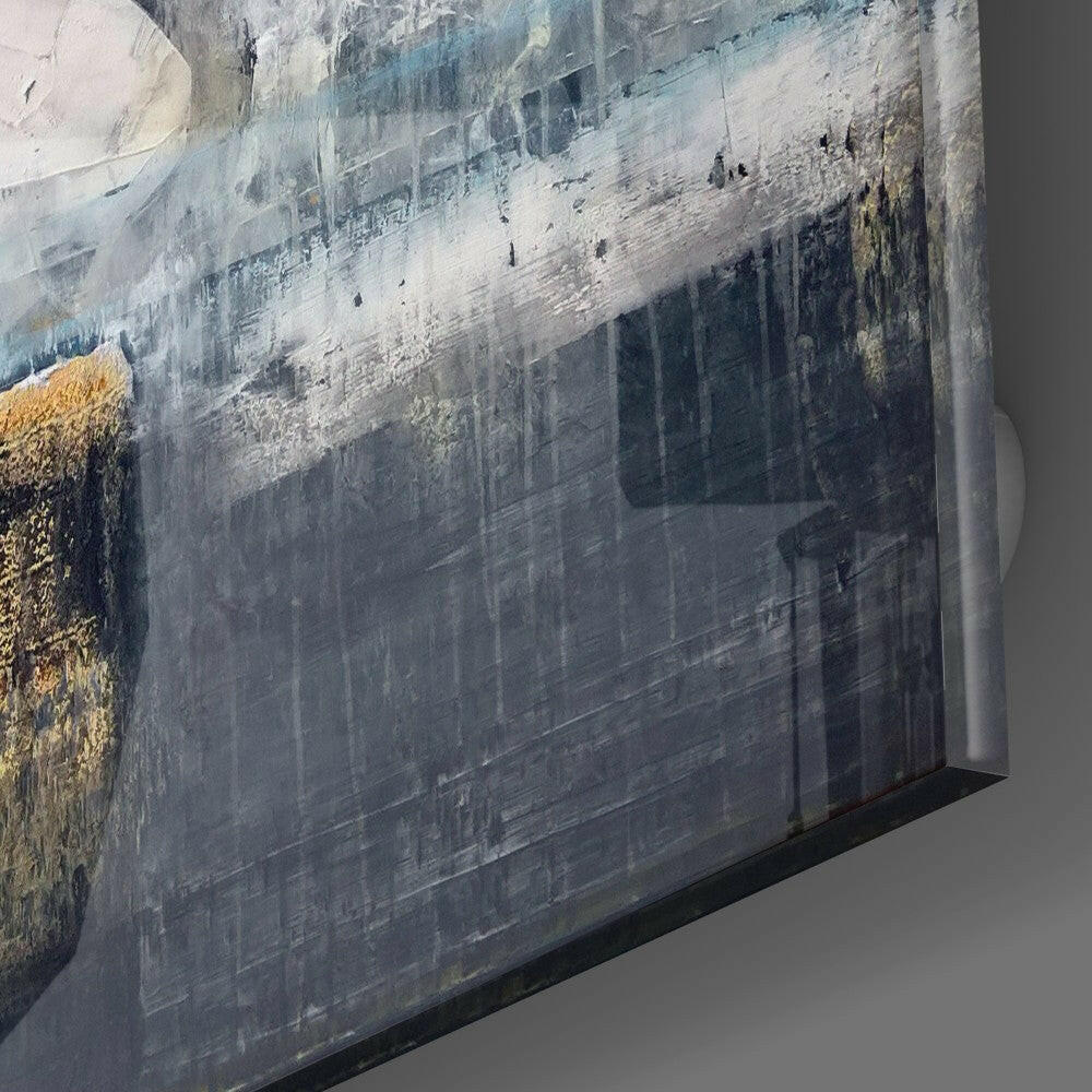 Angled close-up of glass wall art edge showing layered urban architectural landscape with grey tones and gold accents.