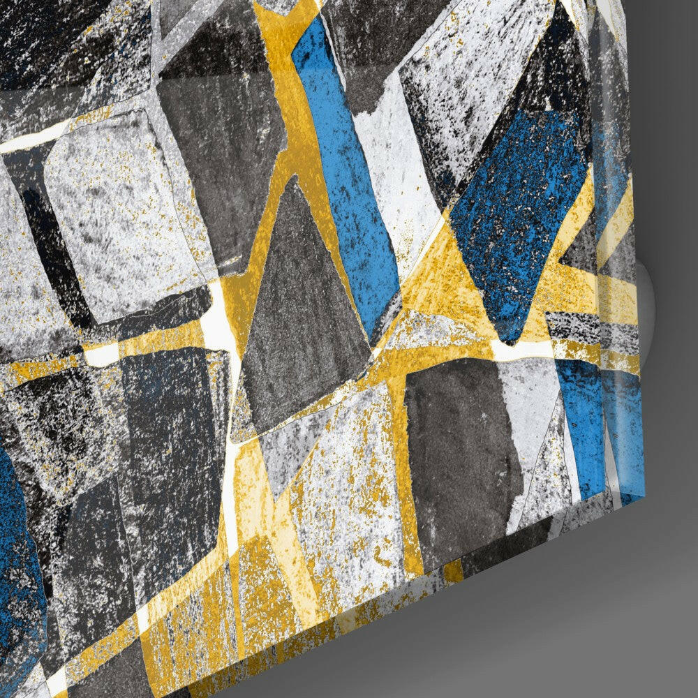 Close-up angled view of textured glass wall art featuring geometric honeycomb pattern in blue, yellow, white, and gray with weathered surface finish.